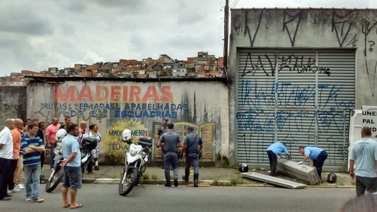 Amigos e parentes observam funcionários do IML (Instituto Médico Legal) retirando corpo do ex-jogador Alves