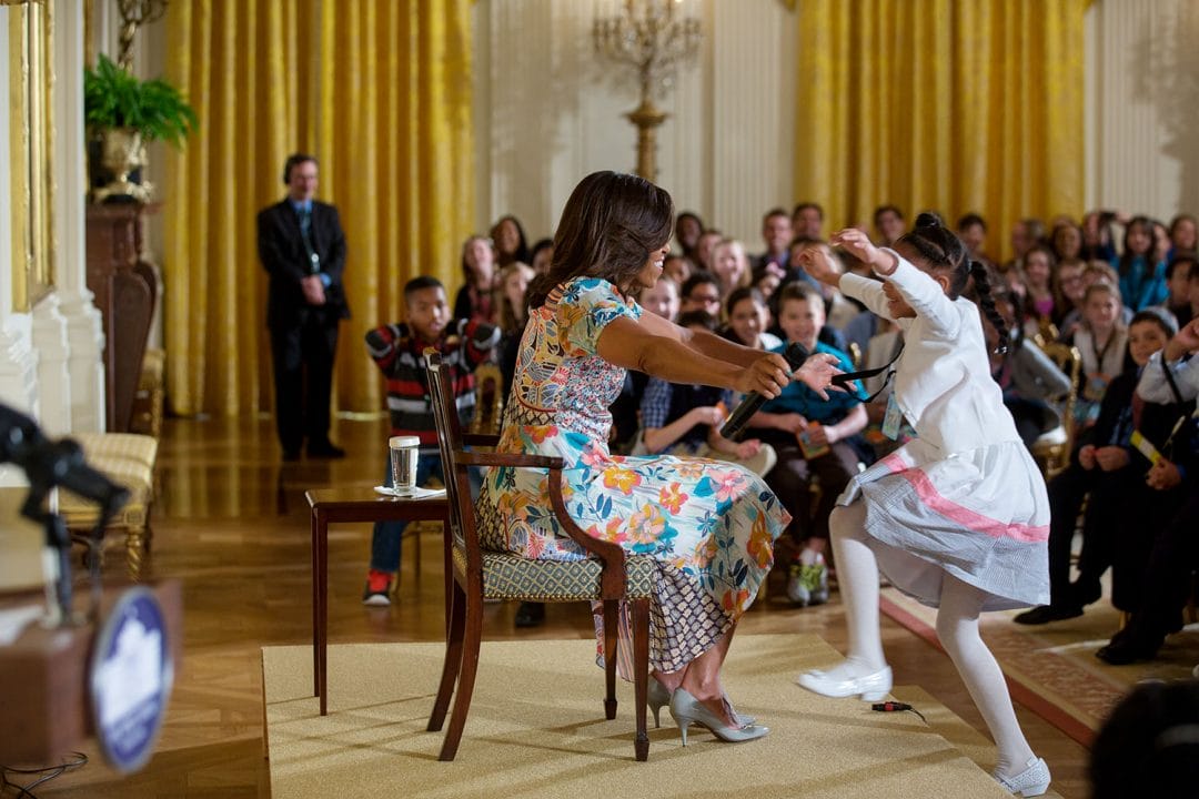 First Lady Michelle Obama reaches out to hug a child attending the annual "Take Our Daughters and Sons to Work Day" event in the East Room of the White House, April 22, 2015. (Official White House Photo by Lawrence Jackson) This official White House photograph is being made available only for publication by news organizations and/or for personal use printing by the subject(s) of the photograph. The photograph may not be manipulated in any way and may not be used in commercial or political materials, advertisements, emails, products, promotions that in any way suggests approval or endorsement of the President, the First Family, or the White House.
