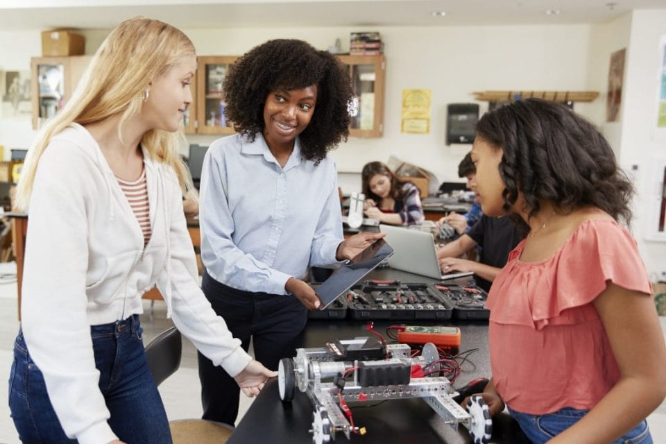 professora ensinando alunas negras e brancas