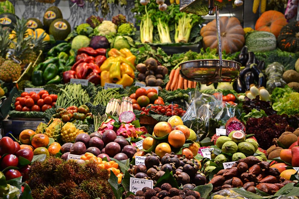 Fotos de vários legumes em uma bancada de feira