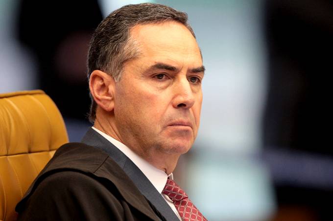 Luís Roberto Barroso- homem branco de cabelo grisalho, vestindo terno e gravata- sentado