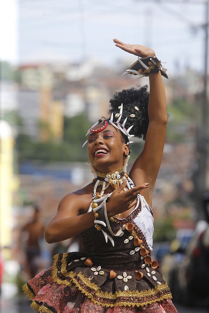 Gleicy Ellen Teixeira, mulher negra, de cabelo cacheado, dançando