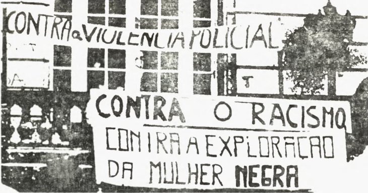 Foto em preto e branco de cartazes contra o racismo e a violência policial